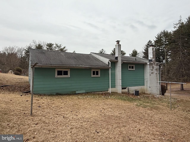 rear view of house featuring a chimney and central AC