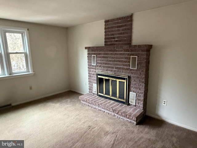 unfurnished living room with carpet floors, a brick fireplace, and baseboards