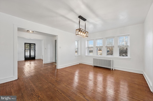 unfurnished dining area with french doors, baseboards, radiator heating unit, and hardwood / wood-style flooring