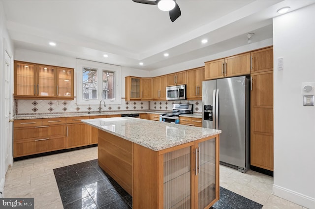 kitchen featuring a center island, stainless steel appliances, recessed lighting, tasteful backsplash, and brown cabinetry