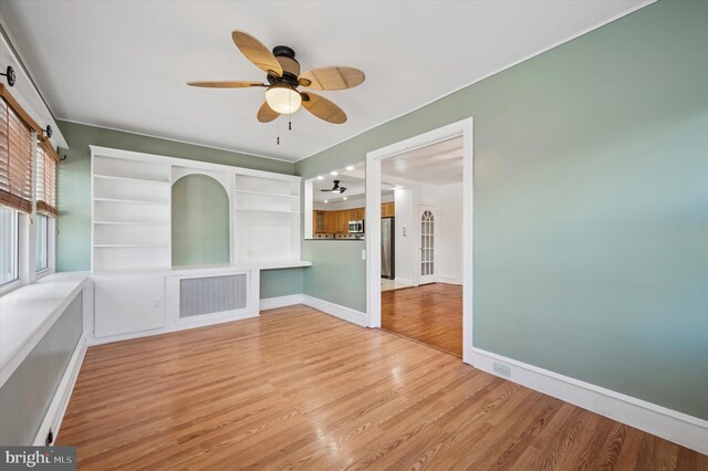 unfurnished room with ceiling fan, baseboards, and wood finished floors