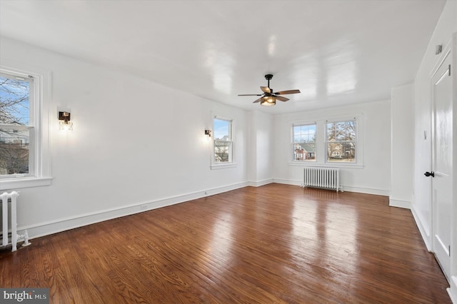 interior space with radiator heating unit, wood finished floors, and baseboards