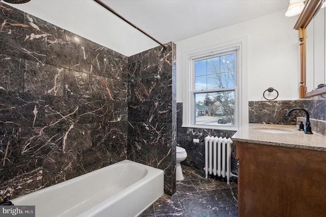 full bath featuring toilet, radiator heating unit, marble finish floor, vanity, and tile walls