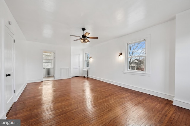 interior space with ceiling fan, wood-type flooring, and radiator heating unit