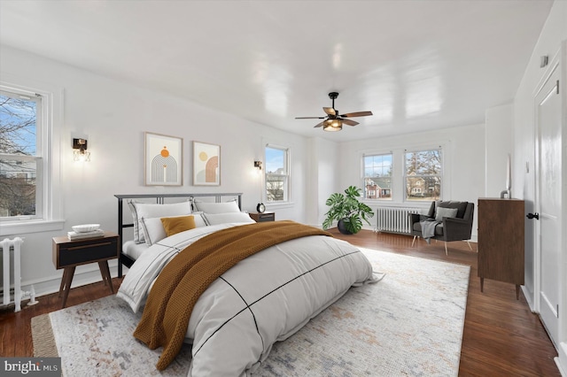 bedroom featuring radiator heating unit, ceiling fan, and wood finished floors