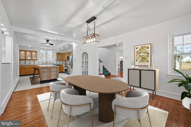 dining area featuring plenty of natural light, stairway, and light wood-style flooring