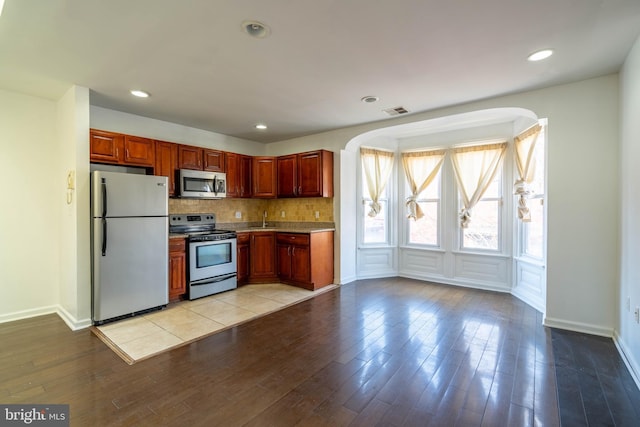 kitchen with light wood-style flooring, recessed lighting, visible vents, appliances with stainless steel finishes, and backsplash