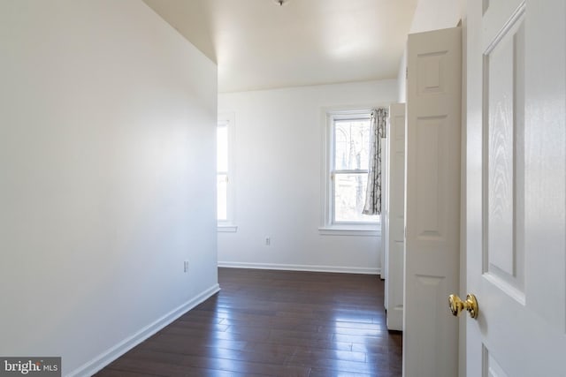 spare room with dark wood-style floors and baseboards