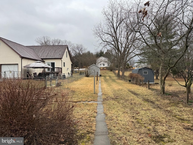 view of yard with a gazebo, a storage unit, an outdoor structure, and fence