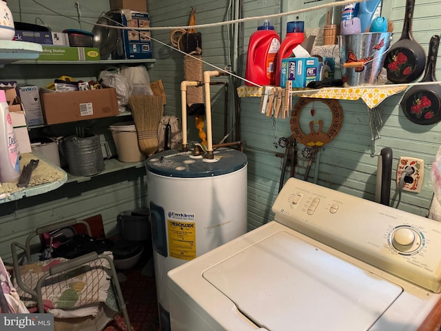 washroom featuring washer / dryer, water heater, laundry area, and wood walls