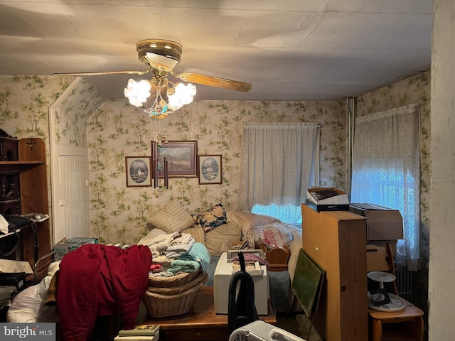 bedroom with ceiling fan and wallpapered walls