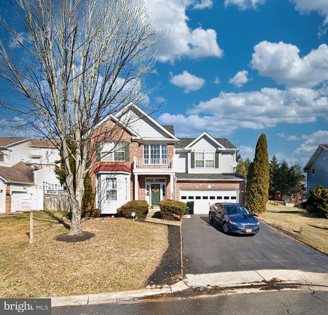 view of front of house with driveway, brick siding, a garage, and a front yard