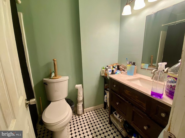 bathroom with vanity, toilet, and baseboards