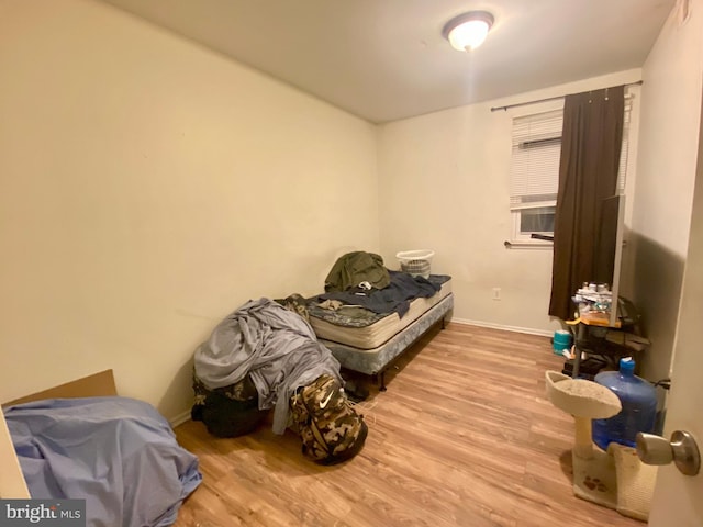 bedroom featuring baseboards and wood finished floors