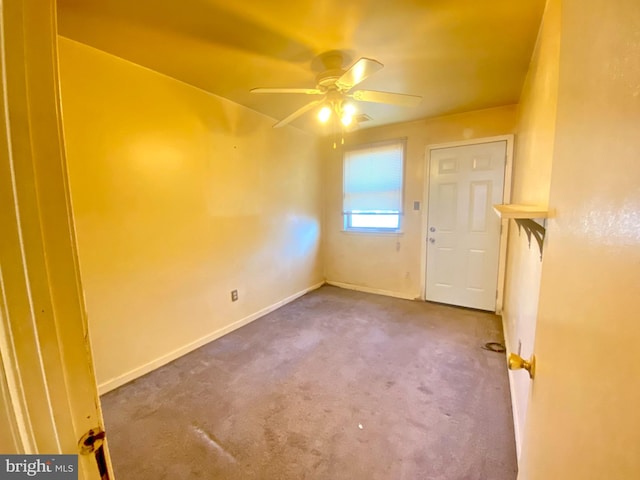 empty room featuring baseboards, ceiling fan, and carpet flooring