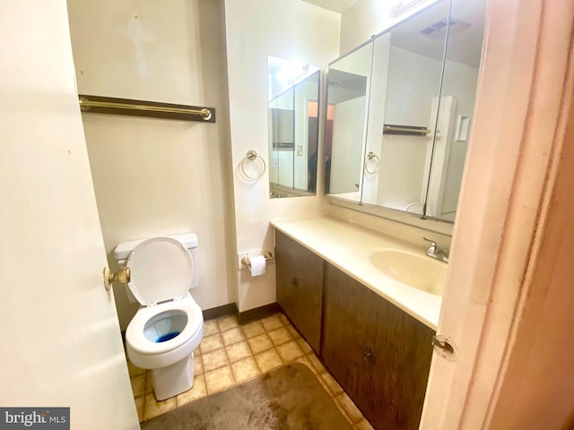 bathroom featuring vanity, toilet, and baseboards