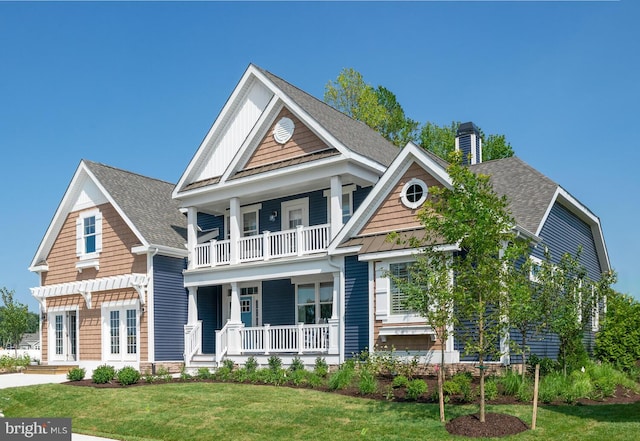 craftsman-style house featuring roof with shingles, a porch, a chimney, and a balcony