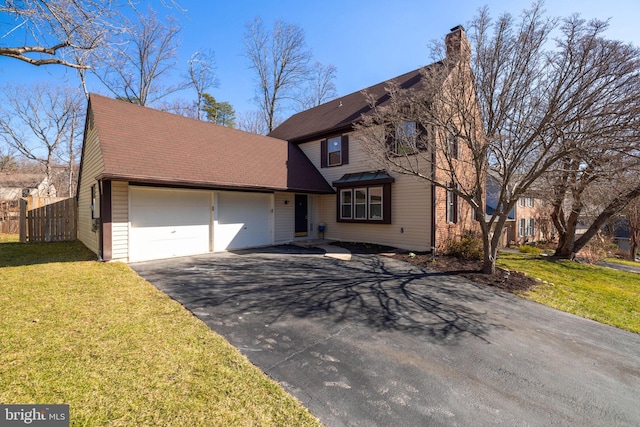 view of front of home featuring fence, a front yard, a chimney, a garage, and driveway