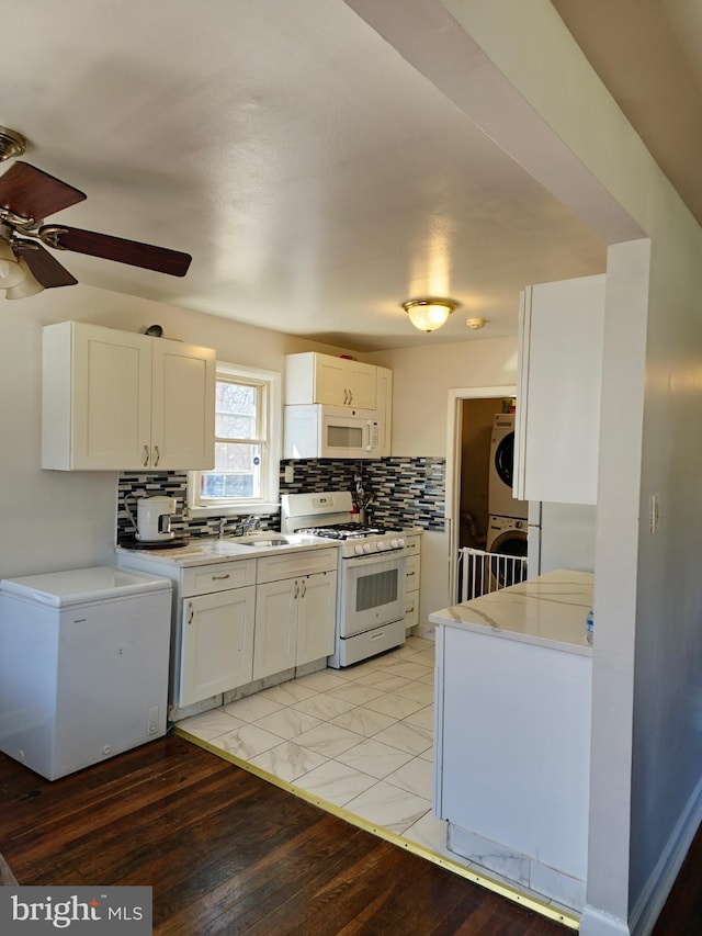 1205 Stratwood Ave, Oxon Hill, MD 20745 - kitchen featuring backsplash, white cabinetry, white appliances, stacked washer / drying machine, and ceiling fan