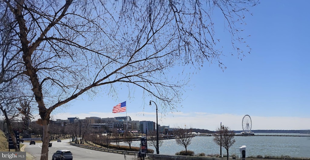 view of road with curbs, a water view, and a city view