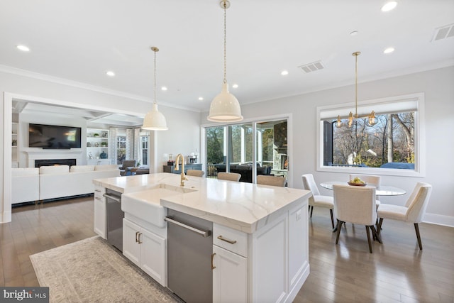 kitchen with ornamental molding, visible vents, a sink, and hardwood / wood-style floors