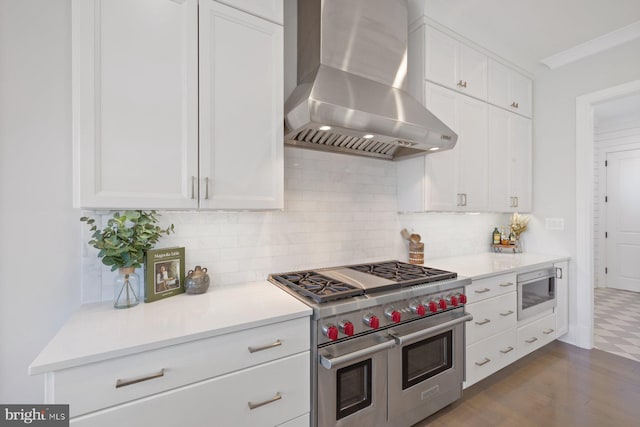 kitchen with white cabinetry, light countertops, wall chimney range hood, double oven range, and tasteful backsplash