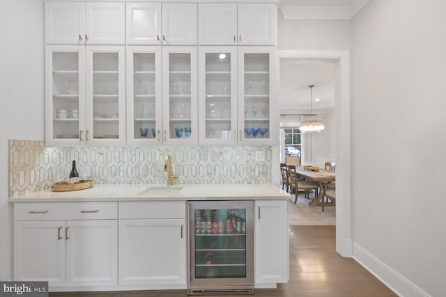 bar with baseboards, decorative backsplash, wine cooler, dark wood-type flooring, and a sink