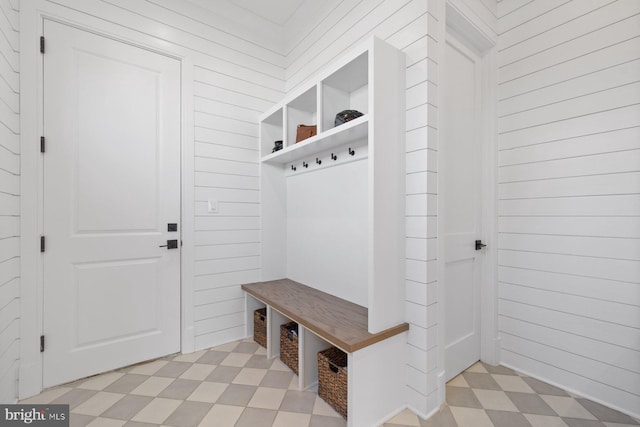 mudroom with wooden walls and light floors