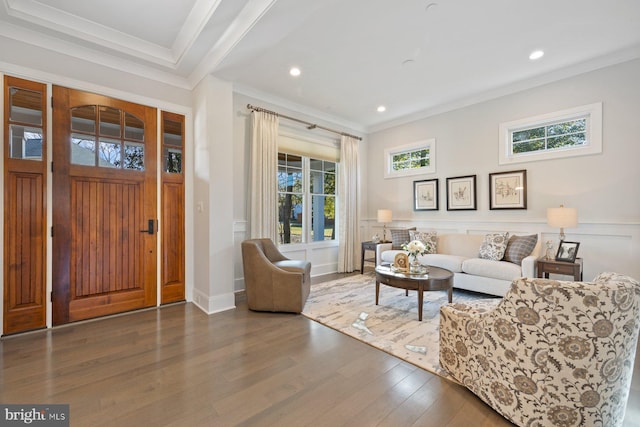 living area featuring wainscoting, ornamental molding, plenty of natural light, and wood finished floors