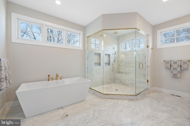 full bath with a stall shower, baseboards, a wealth of natural light, and a soaking tub