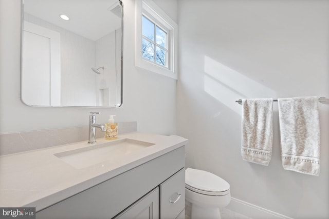 bathroom featuring toilet, recessed lighting, and vanity