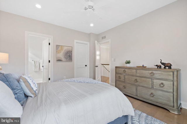 bedroom featuring recessed lighting, visible vents, a ceiling fan, ensuite bath, and wood finished floors