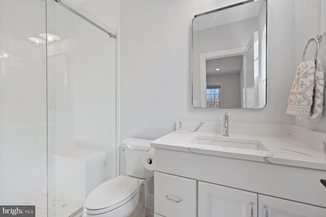 bathroom featuring a stall shower, vanity, and toilet