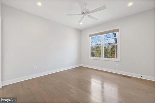 unfurnished room featuring recessed lighting, wood finished floors, visible vents, and baseboards