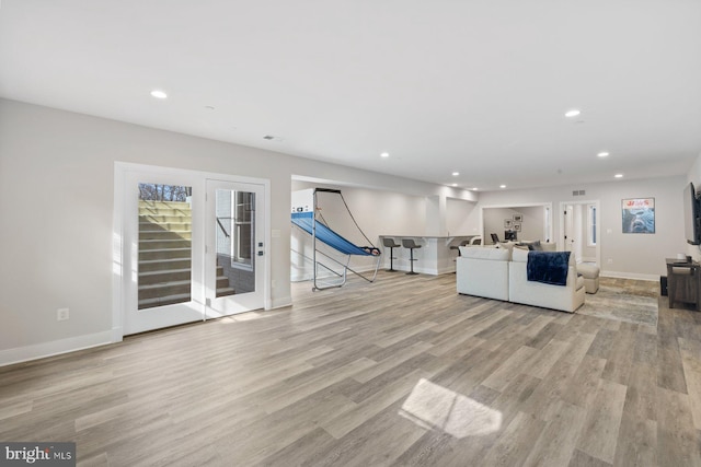 unfurnished living room featuring recessed lighting, baseboards, and wood finished floors