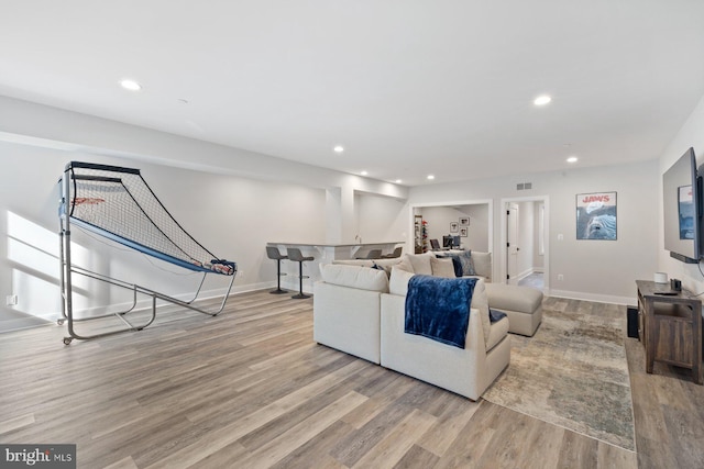 living room with recessed lighting, baseboards, and wood finished floors