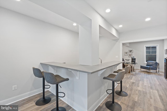 bar with recessed lighting, light wood-style flooring, and baseboards