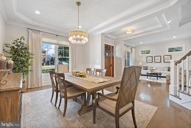 dining area with a decorative wall, ornamental molding, stairway, wainscoting, and wood-type flooring