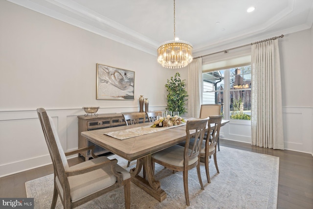 dining room featuring a wainscoted wall, a decorative wall, wood finished floors, and crown molding