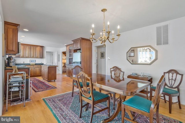 dining area featuring light wood-style floors, recessed lighting, visible vents, and a notable chandelier