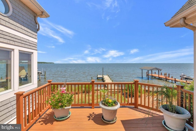 wooden deck featuring a dock, a water view, and boat lift