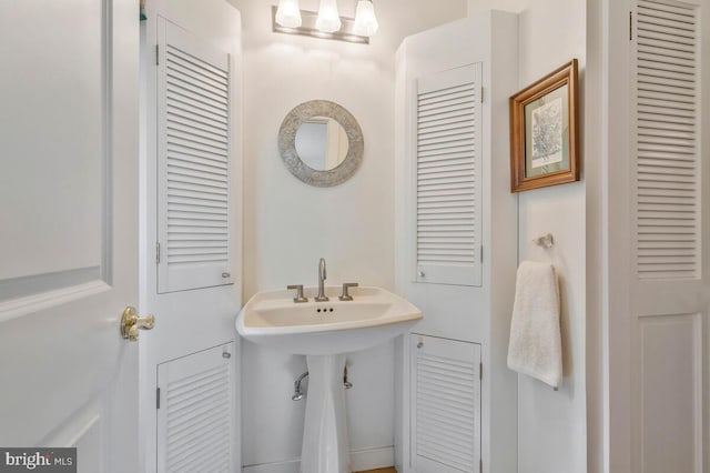 bathroom featuring a closet and a sink