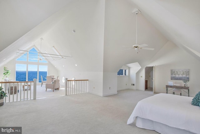 carpeted bedroom with high vaulted ceiling, a water view, and baseboards