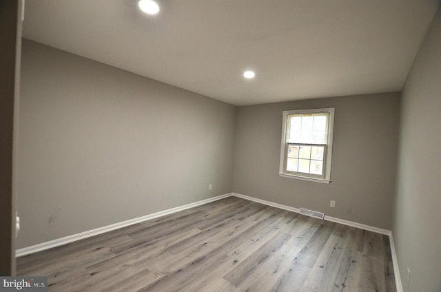 unfurnished room with recessed lighting, visible vents, baseboards, and wood finished floors