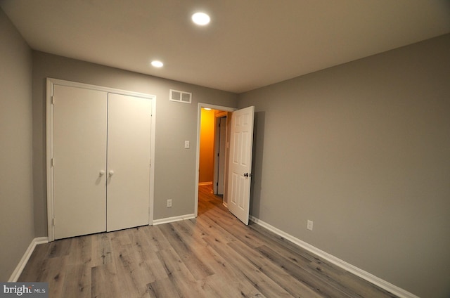 unfurnished bedroom featuring visible vents, recessed lighting, light wood-type flooring, and baseboards