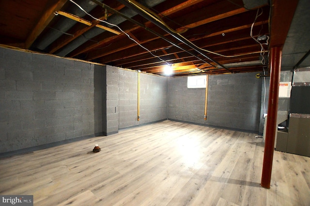 basement featuring heating unit and wood finished floors