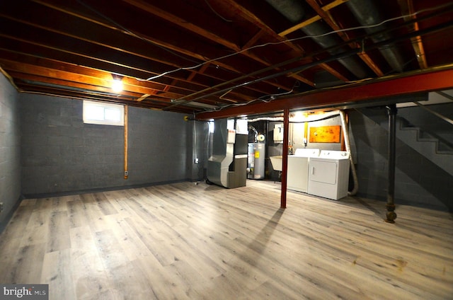 basement featuring heating unit, wood finished floors, water heater, and washer and clothes dryer