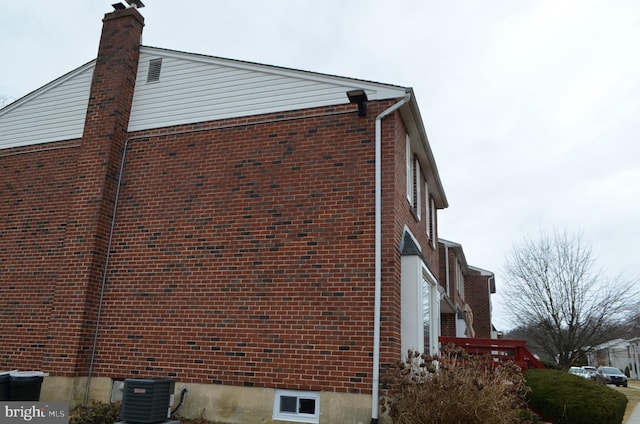 view of side of property with brick siding and cooling unit