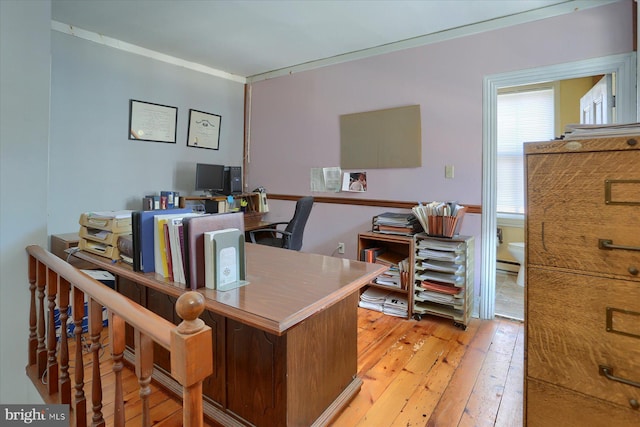 office with light wood finished floors, baseboard heating, and crown molding