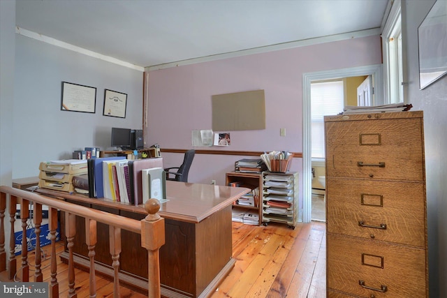 office featuring light wood-type flooring, a baseboard radiator, and crown molding